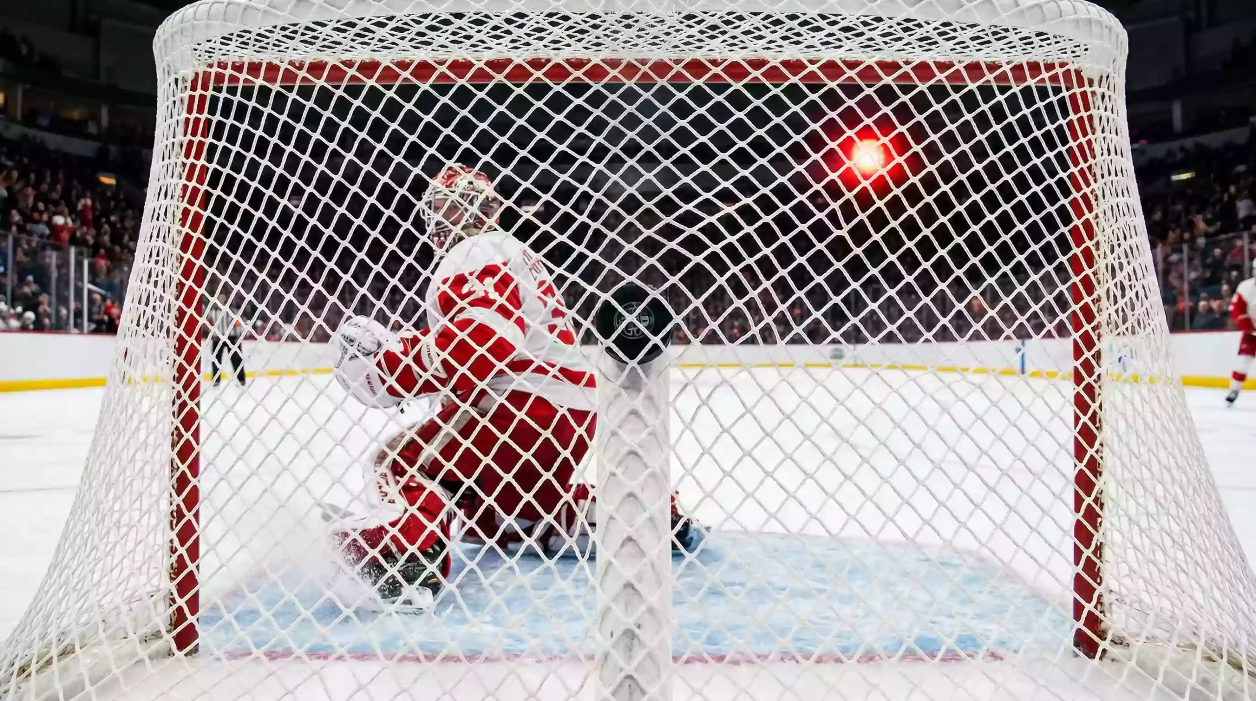 Eishockey Puck fliegt ins Tornetz bei einem Treffer